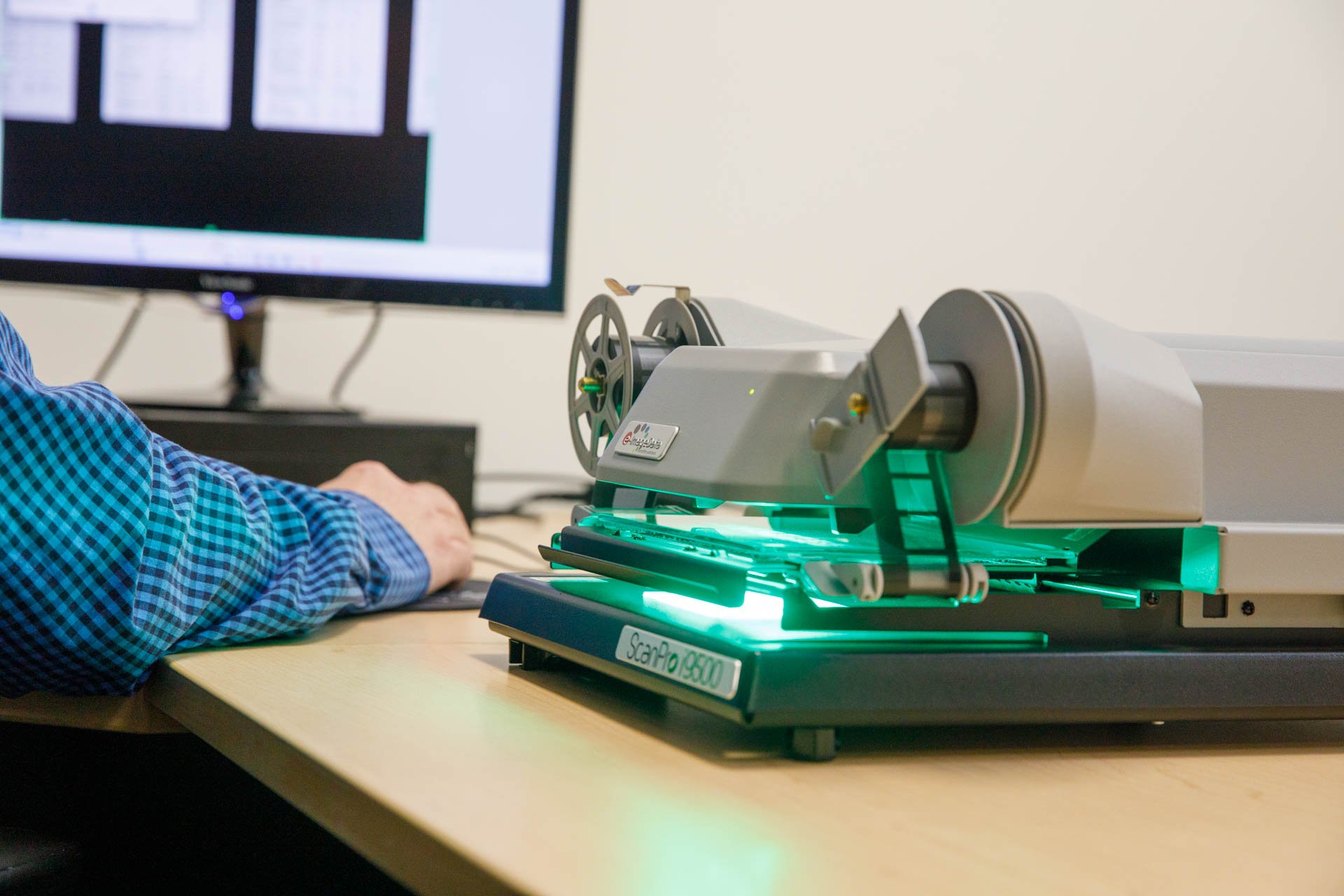 an image of microfilm being scanned by eo johnson's bulk document scanning professionals