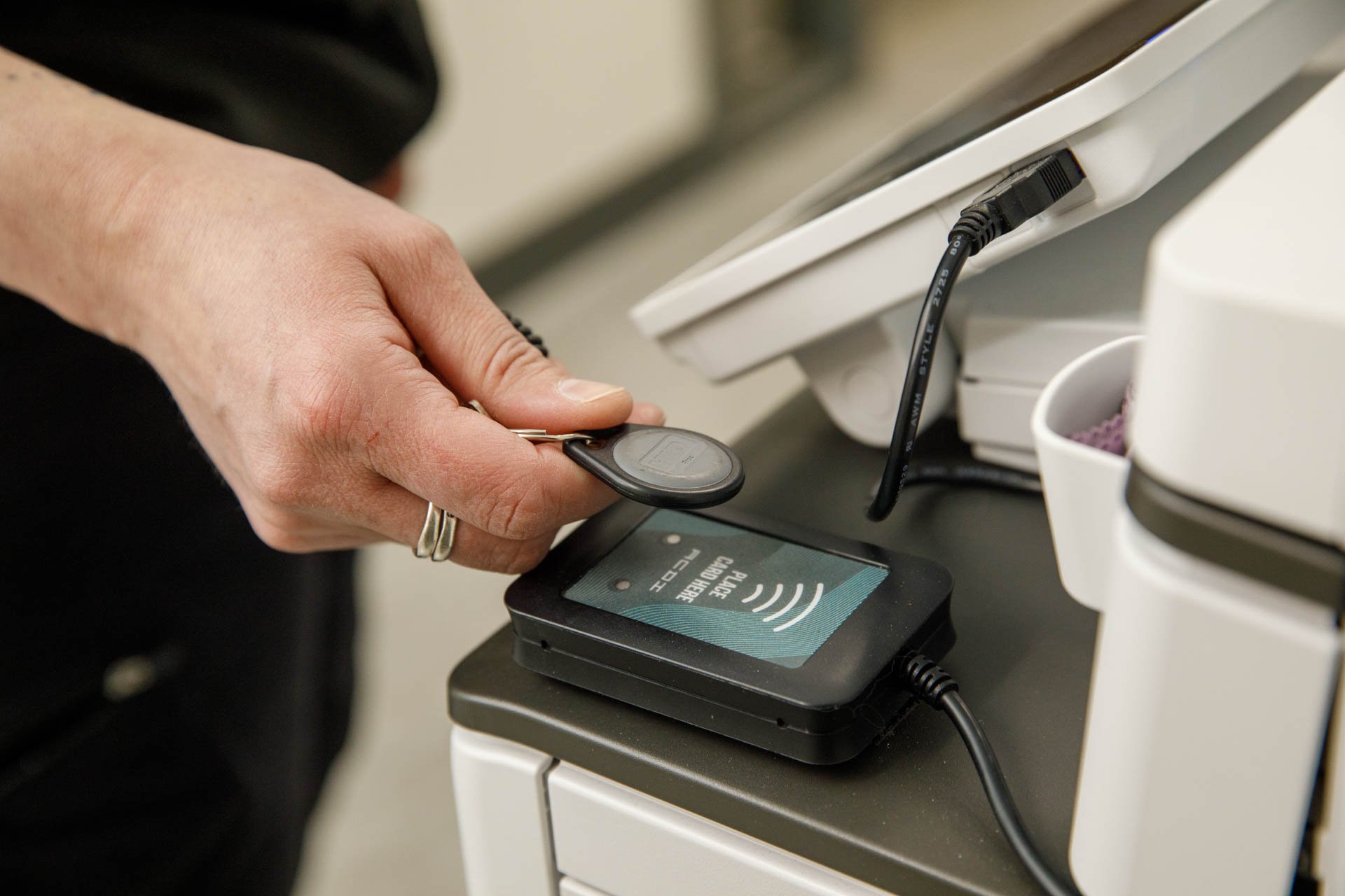 an image of a professional using a fob to access the print queue on a multifunction device from eo johnson