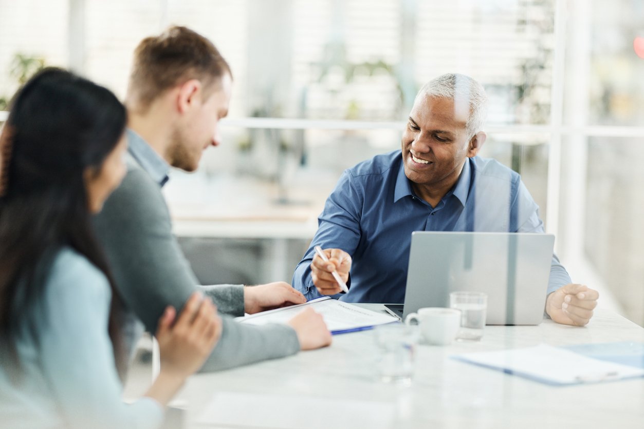 Image of a loan officer going over documents with his clients