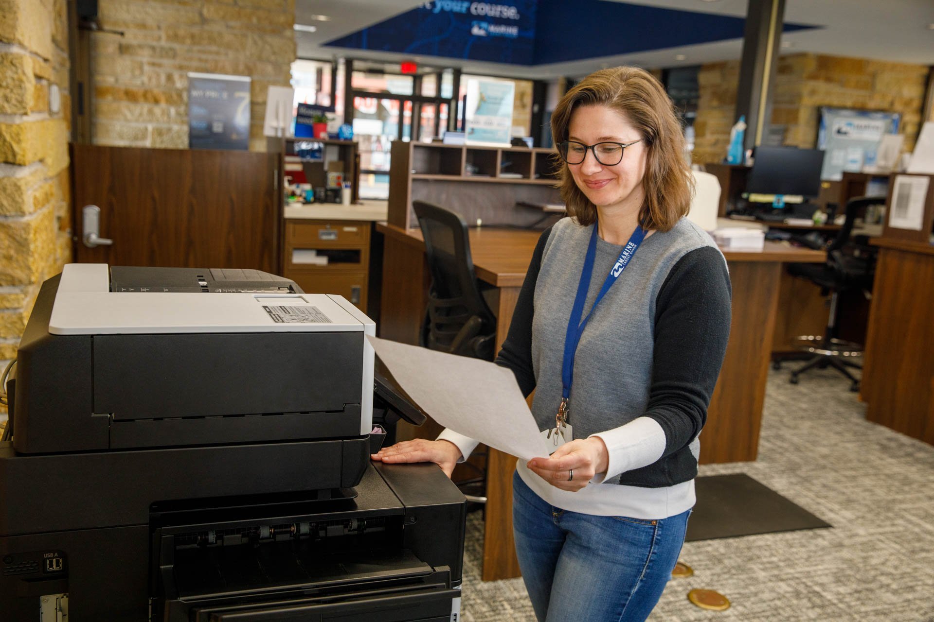 an image of a banking professional grabbing a document off a printer from eo johnson