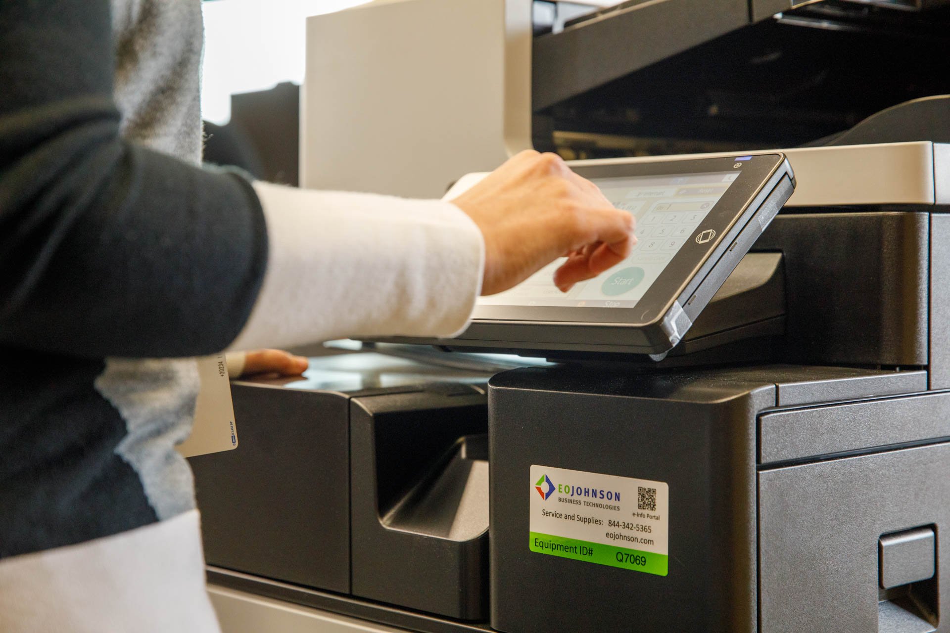 an image of an administrative professional using a copier in an office setting