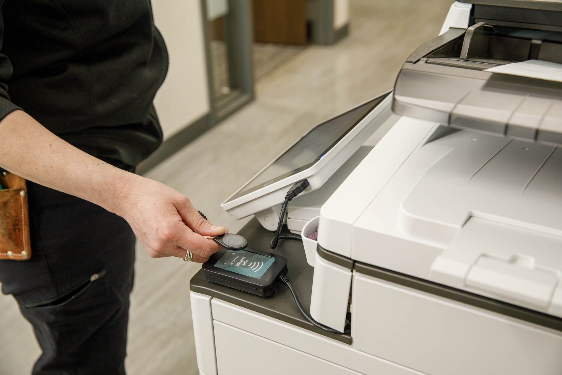 image of warehouse employee using secure access controls to print or scan files on a multifunction device from eo johnson business technologies