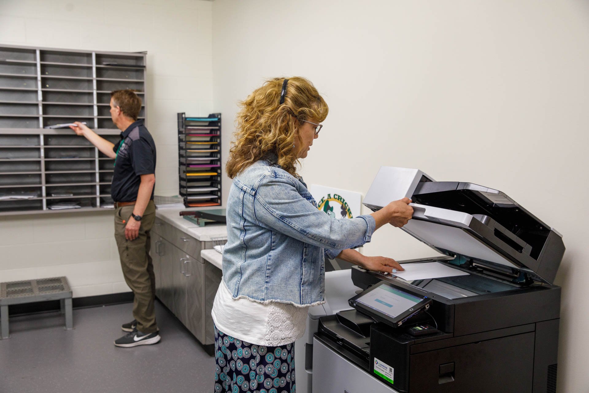 An image of a teacher making a copy in the office at a school