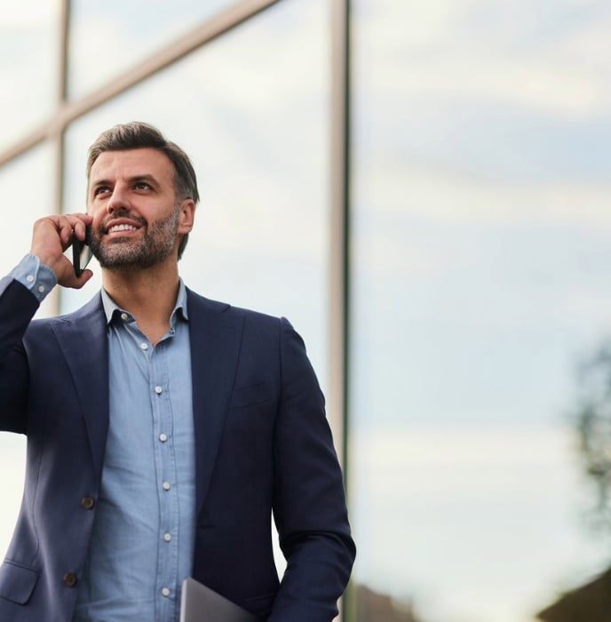 image of a business professional carrying his laptop and talking on his phone