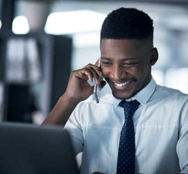 an image of a professional talking on the phone while accessing his computer