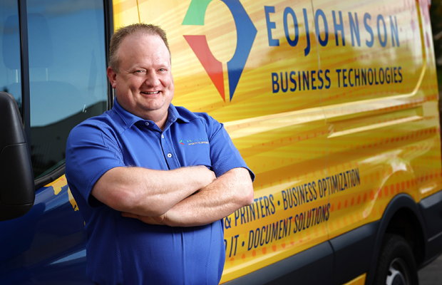 an image of an eo johnson printer service technician standing by his service truck smiling with his arms crossed
